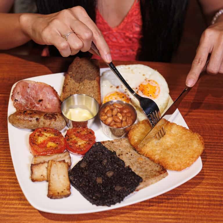 Half Irish Breakfast with 1 back bacon, 1 sausage, grilled tomato, king oyster mushrooms, baked beans, black & white pudding, 1 hash brown, Irish soda bread & choice of 2 eggs (fried, soft boiled, poached or scrambled)